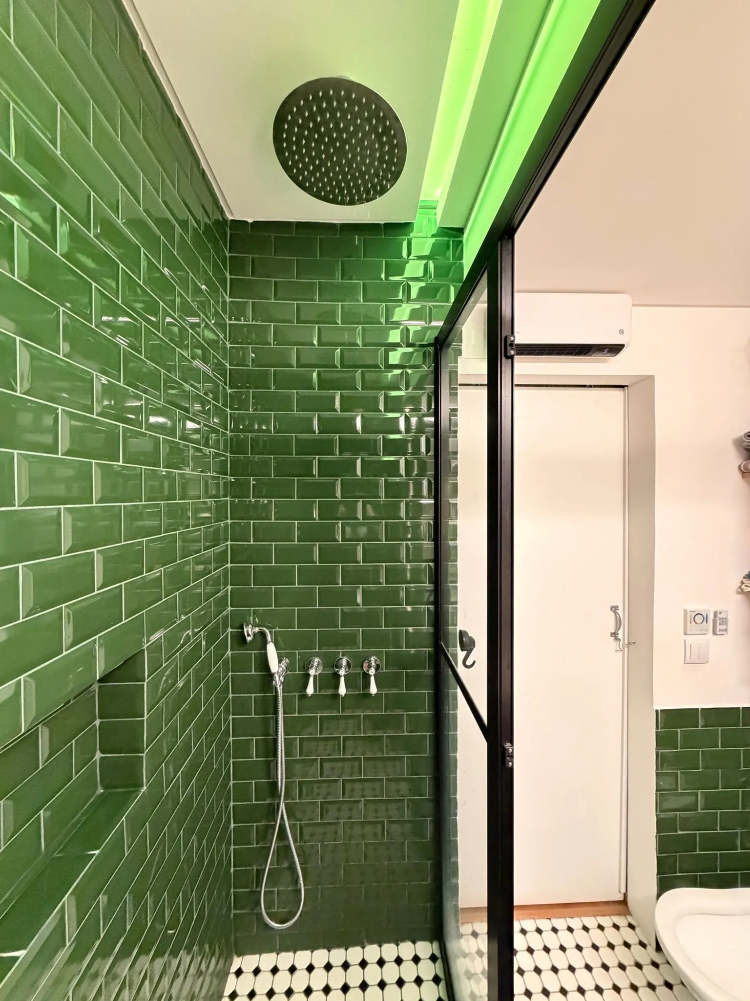 Duche revestido a azulejo metro verde, com resguardo de vidro e caixilho preto