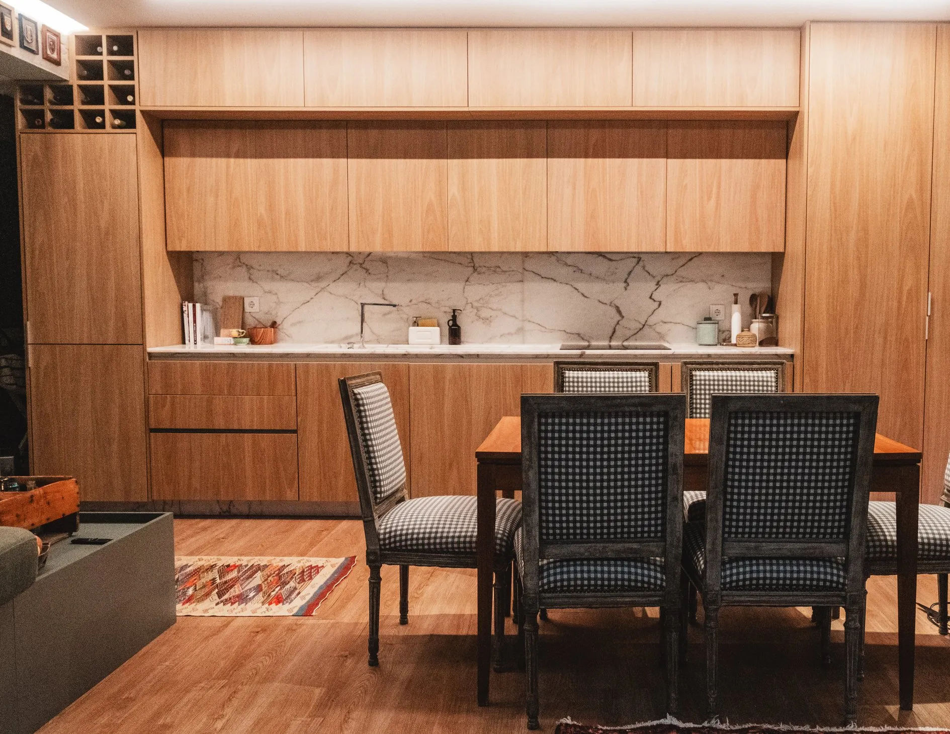 Sala de jantar e cozinha em madeira, bancada em mármore e cadeiras em xadrez